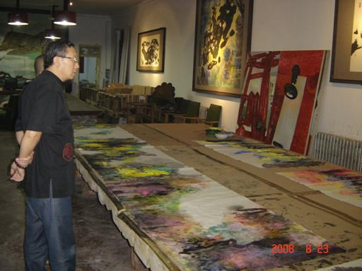 巨大的画桌,上面留下许多画家曾挥毫作画的色彩痕迹,墙上是已经完成的作品。